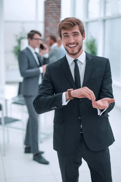 Vänlig ung affärsman står på kontoret. — Stockfoto