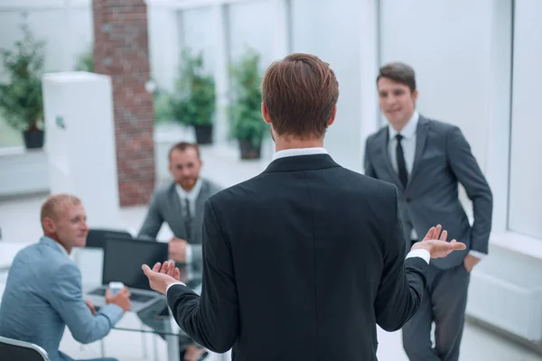 Vista trasera. empresario explicando las tareas actuales del equipo empresarial . —  Fotos de Stock