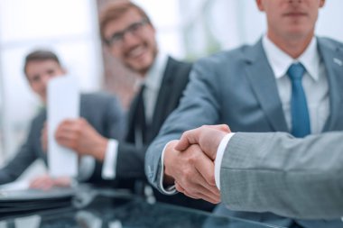 Ciddi bir iş adamı iş ortağıyla el sıkışıyor.