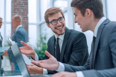 Kapat. İş arkadaşları ofiste bir dizüstü bilgisayar üzerinde çalışıyorlar.