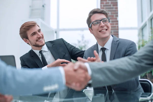 Håndhilsing av forretningsfolk med uklar kontorbakgrunn . – stockfoto