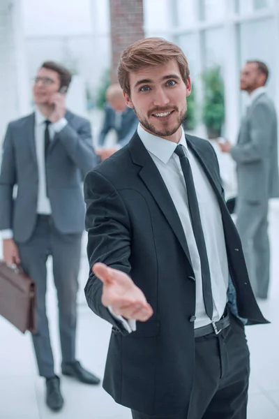 Sonriente hombre de negocios extendiendo su mano para un apretón de manos . — Foto de Stock