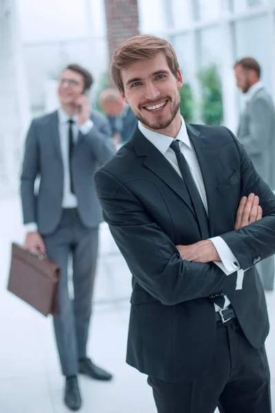 Усміхнений бізнесмен стоїть в сучасному офісі — стокове фото