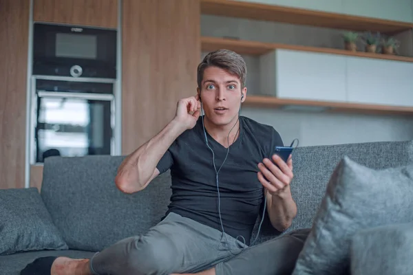 Joven guapo escuchando música a través de auriculares — Foto de Stock