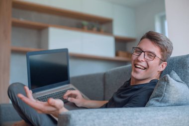 Kapat. Mutlu genç adam rahat kanepede yatıyor..