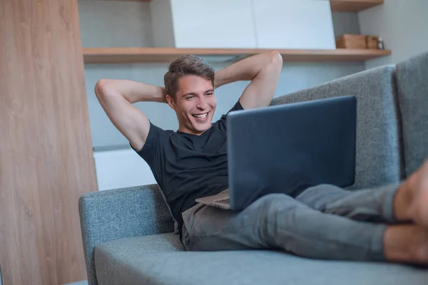 Молодий чоловік дивиться відео на свій ноутбук — стокове фото