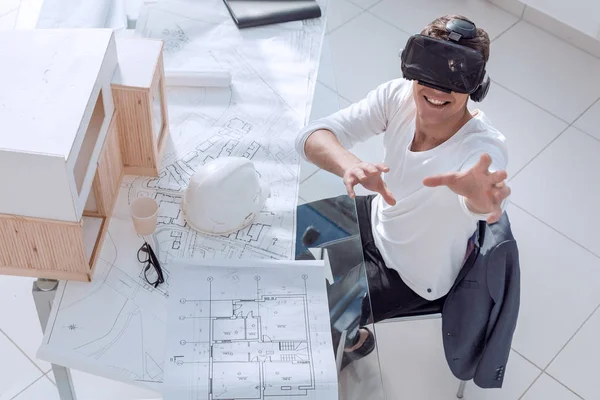 Arquitecto en casco de realidad virtual sentado a la mesa — Foto de Stock