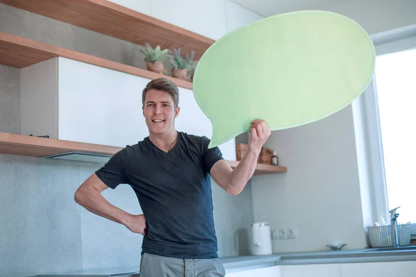 Smiling man with balloon for text standing in new kitchen — Stock Photo, Image
