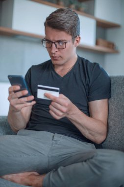 Gülümseyen adam online olarak koltukta oturuyor.