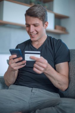 Gülümseyen adam online olarak koltukta oturuyor.