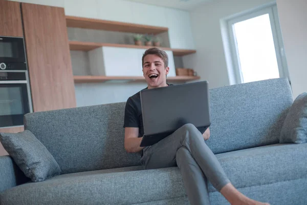 Joven serio está trabajando en un ordenador portátil en su apartamento —  Fotos de Stock