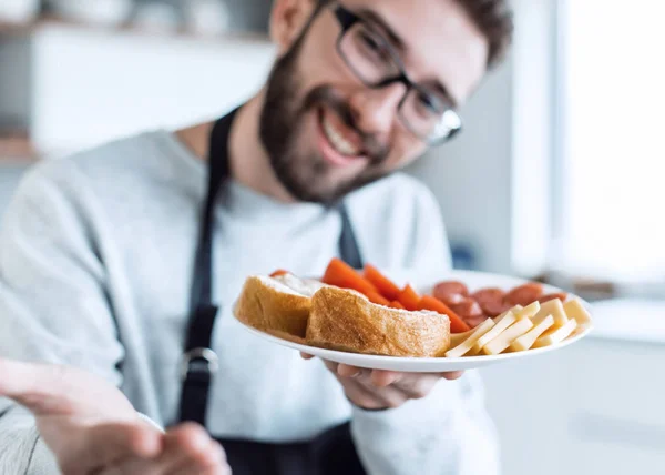 Egy tál szendvics egy vonzó férfi kezében. — Stock Fotó