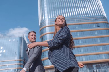 Genç çalışanlar sokakta iş merkezine doğru yürüyorlar.