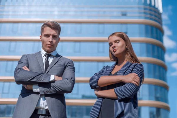 Pewni siebie młodzi profesjonaliści stojący w pobliżu dużego biurowca — Zdjęcie stockowe
