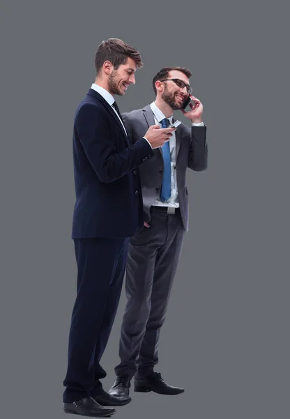 Longitud total. dos hombres de negocios usando sus teléfonos inteligentes — Foto de Stock