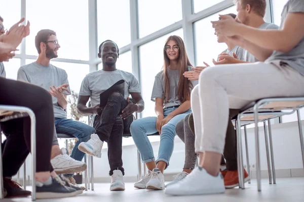 Orateur souriant assis dans un cercle de jeunes — Photo