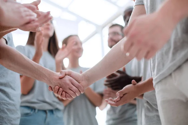 Handdruk van jongeren op de achtergrond van het applaudisserende team — Stockfoto