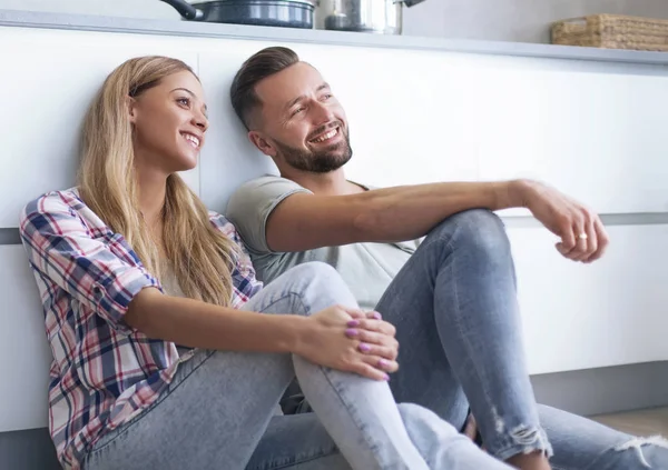 Coppia felice discutendo qualcosa seduto sul pavimento della cucina — Foto Stock