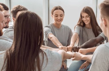 Kapat. Kendine güvenen genç takım ellerini birleştiriyor.