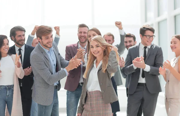 Szczęśliwa młoda kobieta stoi przed jej Jubilant kolegów — Zdjęcie stockowe