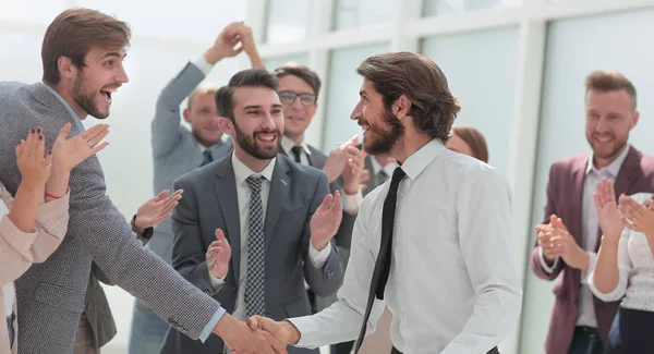 Счастливая команда бизнесменов поздравляет молодых деловых партнеров — стоковое фото