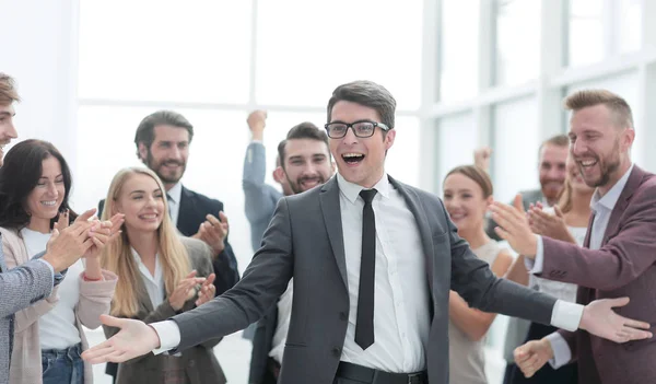 Homem de negócios feliz em pé entre seus colegas. — Fotografia de Stock