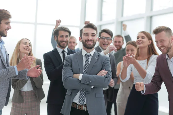 Confiante orgulhoso empresário em pé na frente de uma equipe de negócios amigável . — Fotografia de Stock