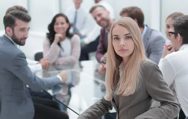 serious business woman sitting at a table in a conference room