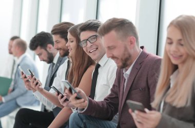 Bir grup genç ofis lobisinde oturuyor.