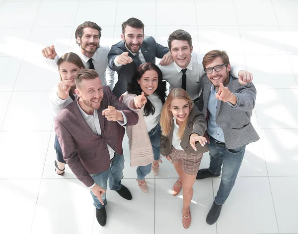 Ansicht von oben. eine Gruppe lächelnder junger Geschäftsleute zeigt auf dich. — Stockfoto