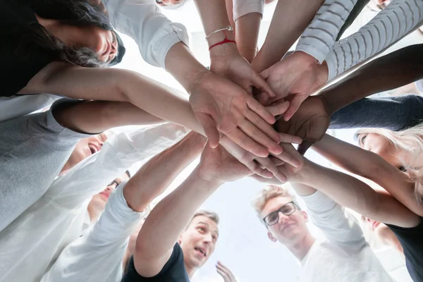 Ansicht von unten. Gruppe junger Menschen verbindet ihre Handflächen — Stockfoto