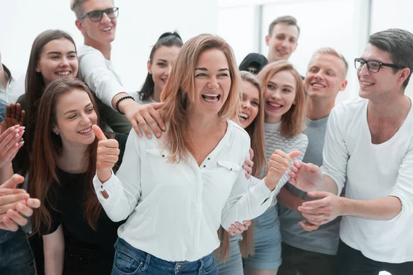 Gruppe junger Menschen unterstützt ihren glücklichen Führer — Stockfoto