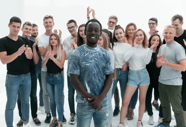Happy guy standing among a group of his friends — Stock Photo, Image