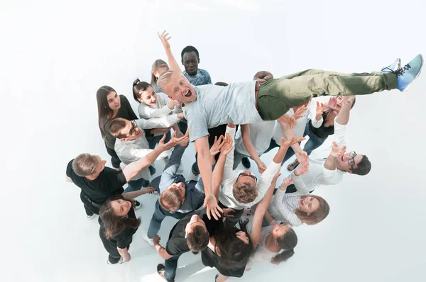 Top view.happy equipo de jóvenes sacudiendo a su líder. — Foto de Stock