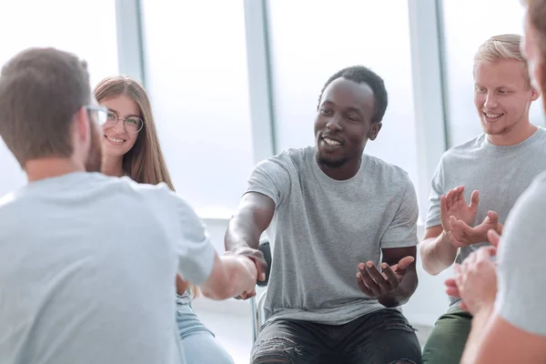 Poignée de main de jeunes dans un cercle de personnes partageant les mêmes idées — Photo