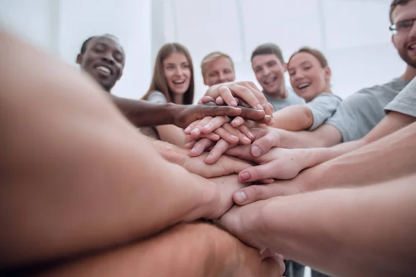 Nahaufnahme. Internationale Gruppe junger Menschen, die ihre Hände zusammenlegen — Stockfoto