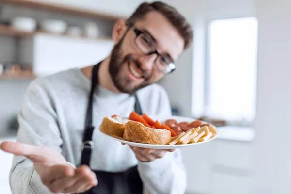 Bord sandwiches in de handen van een aantrekkelijke man — Stockfoto