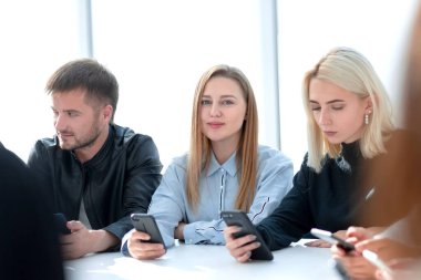 Yuvarlak bir masada oturan bir grup genç.