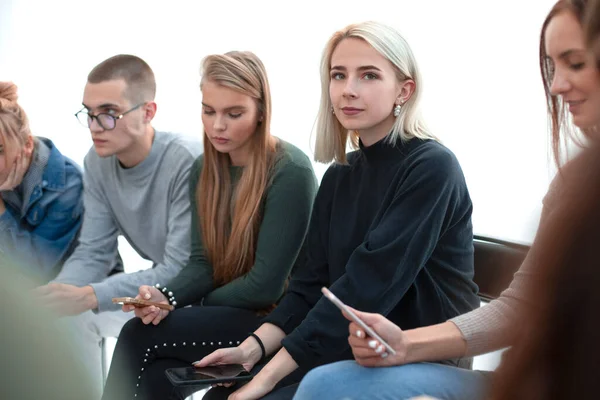 De près. femme avec smartphone assis parmi ses amis — Photo