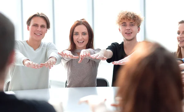 Grupo concentrado de jóvenes sentados en una mesa redonda — Foto de Stock