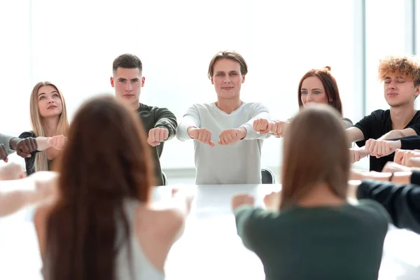 Fokussierte Gruppe junger Menschen sitzt an einem runden Tisch — Stockfoto