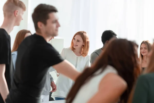 Gruppe unterschiedlicher junger Leute steht um einen runden Tisch — Stockfoto