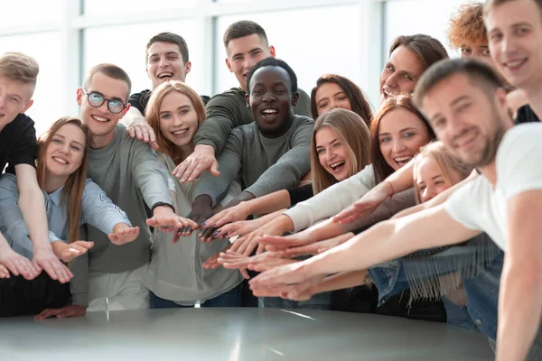 Grupo de jóvenes sonrientes que se unen a sus manos — Foto de Stock