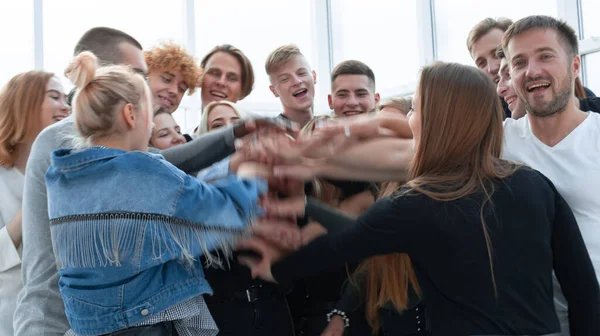 Velká skupina mladých lidí spojuje své ruce. — Stock fotografie