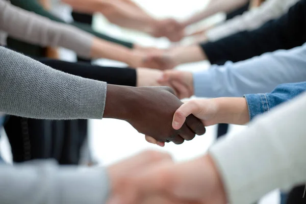 De cerca. diversos jóvenes estrechándose la mano entre sí. — Foto de Stock