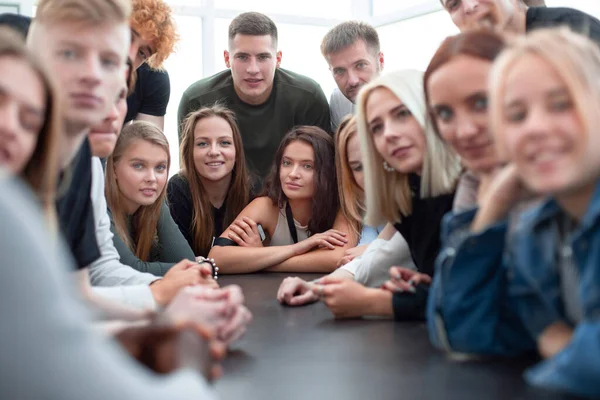 Veel verschillende jongeren zitten aan één tafel — Stockfoto