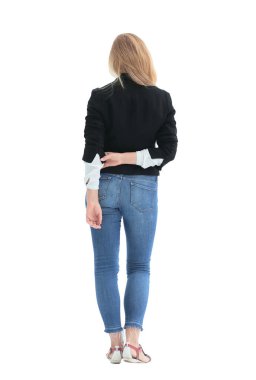 Dikiz aynası. Beyaz bir duvarın önünde duran kendinden emin genç bir kadın..