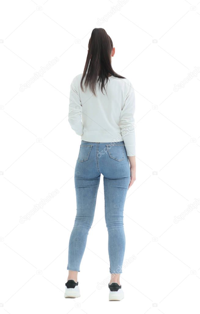 rear view. stylish girl in jeans standing in front of a white wall.