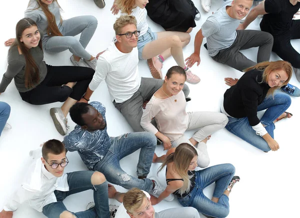 Stor tillfällig grupp ungdomar som sitter på golvet. — Stockfoto