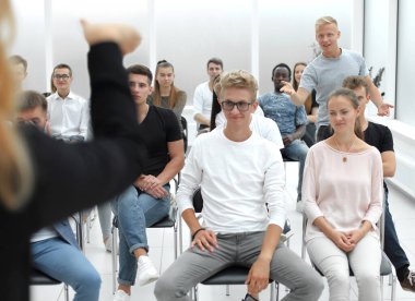 Çeşitli seminer dinleyicileri konferans odasında oturuyorlar..